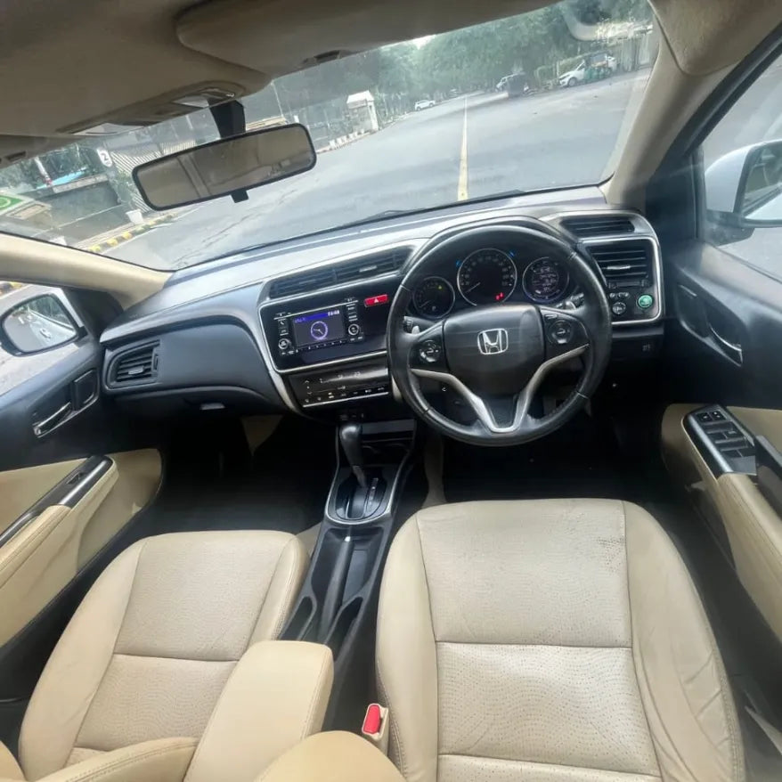 Car interior with dashboard and steering wheel of a Honda vehicle.