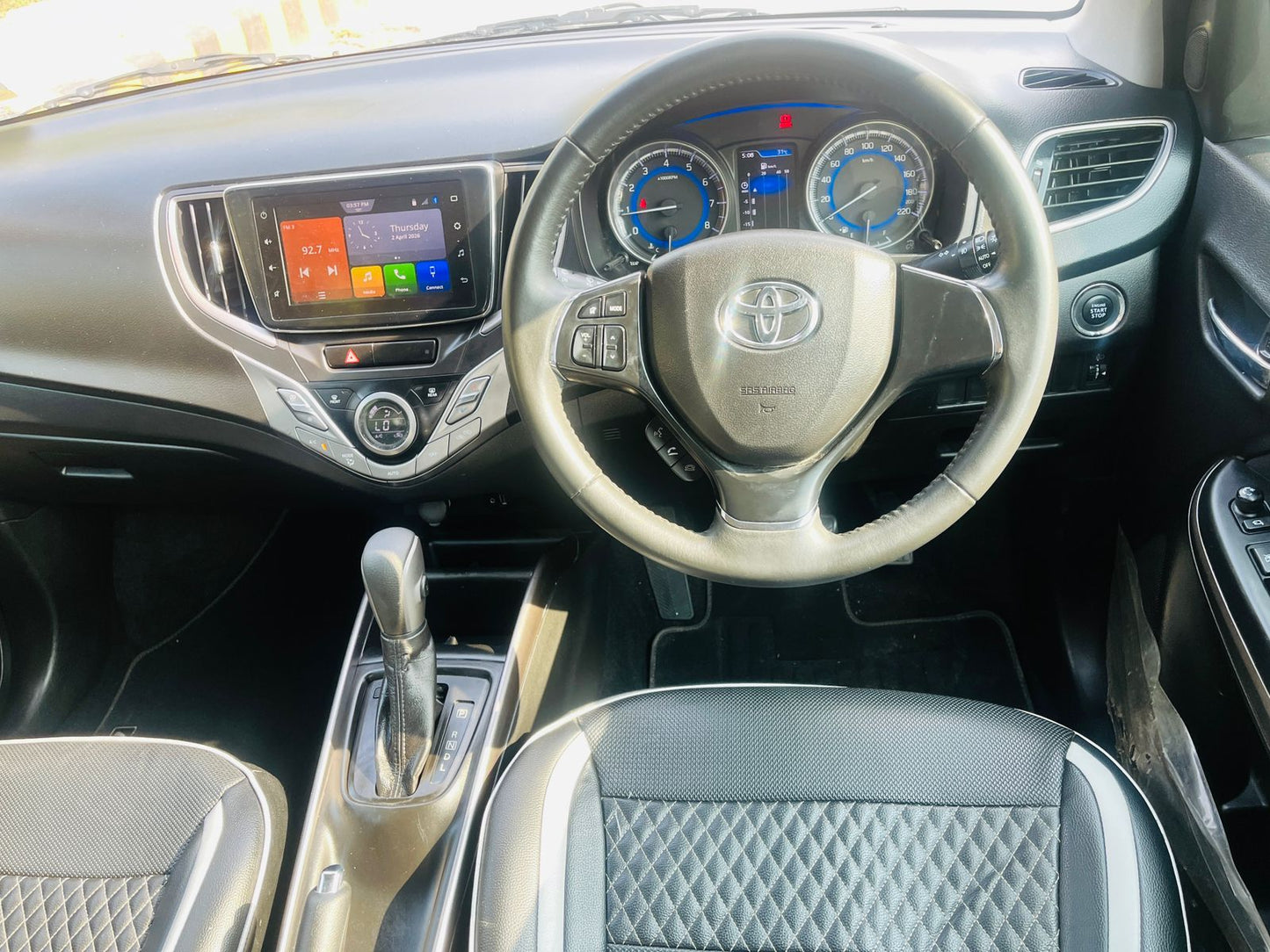 Car interior with steering wheel and dashboard featuring Toyota logo