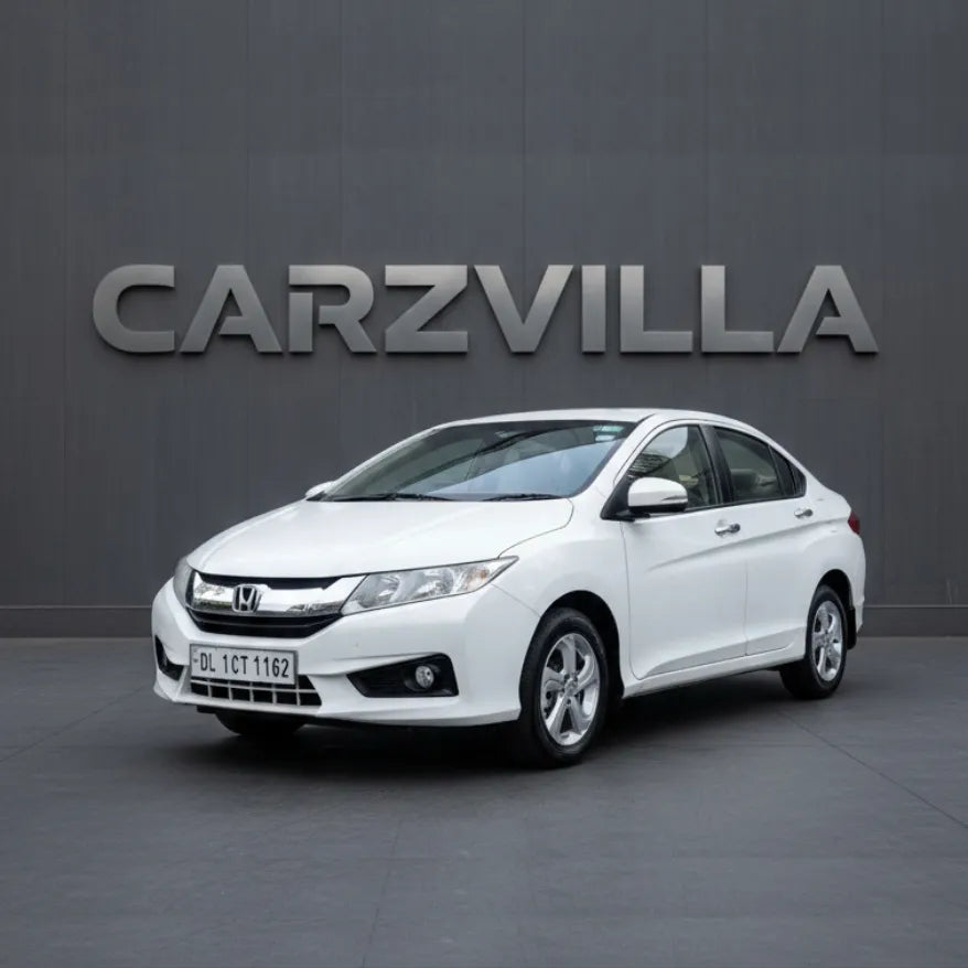 White car parked in front of a gray wall with 'CARZVILLA' branding.