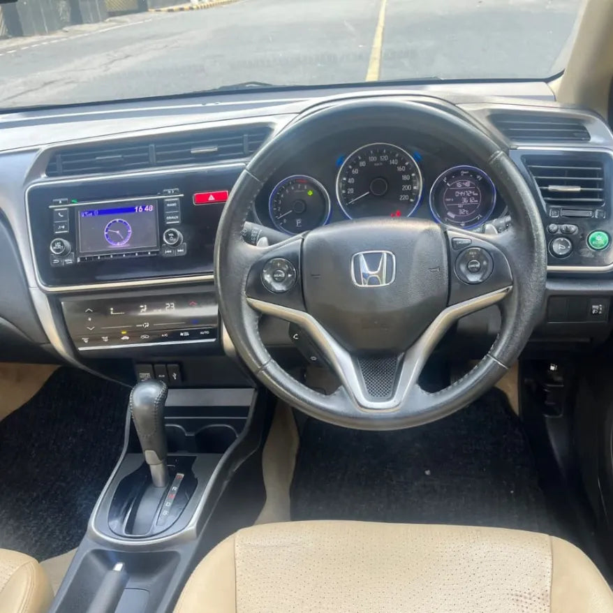 Car interior with steering wheel and dashboard of a Honda vehicle.