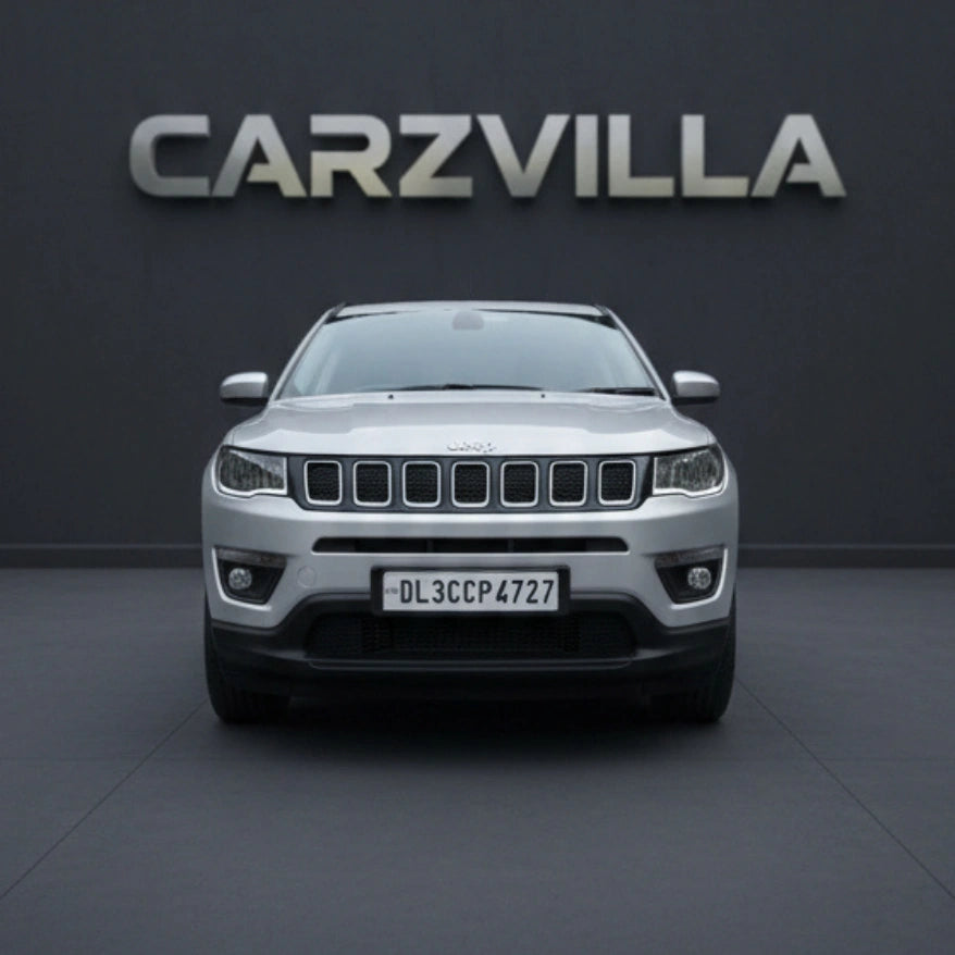 Silver SUV in front of a dark background with 'CARZVILLA' branding.