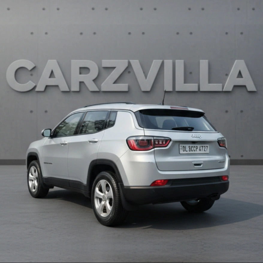 White SUV parked in front of a gray wall with 'CARZVILLA' branding.
