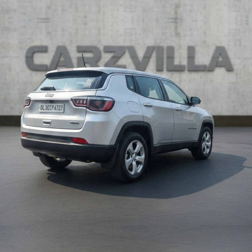 Silver SUV parked in front of a concrete wall with 'CARZVILLA' branding.