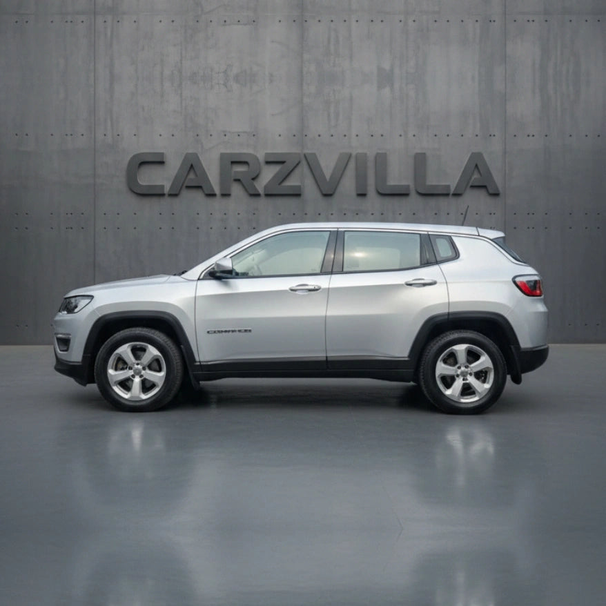 Silver SUV parked in front of a gray wall with 'CARZVILLA' branding.