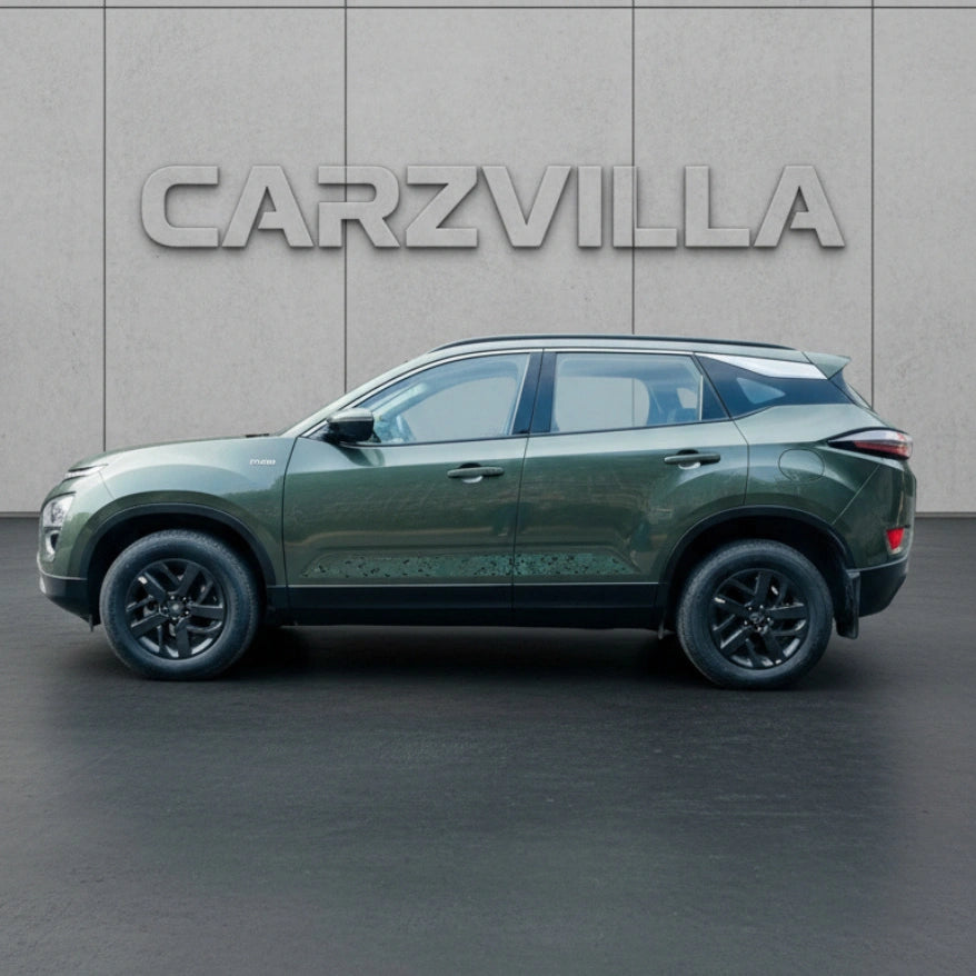Green SUV parked in front of a gray wall with 'CARZVILLA' branding.