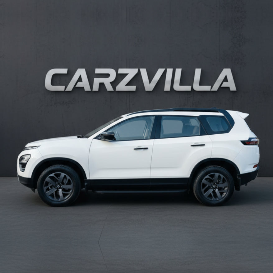 White SUV parked in front of a dark wall with 'CARZVILLA' branding.