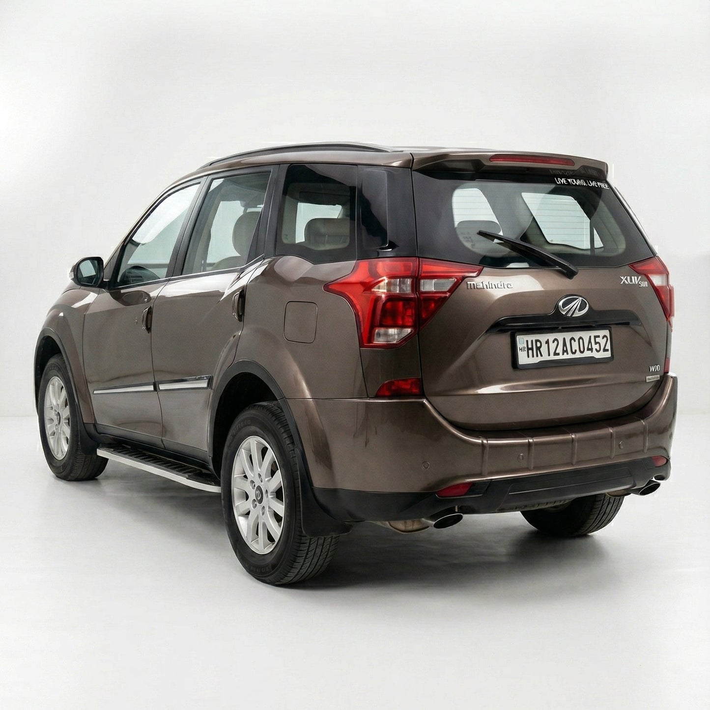 Brown SUV with a visible license plate on a white background