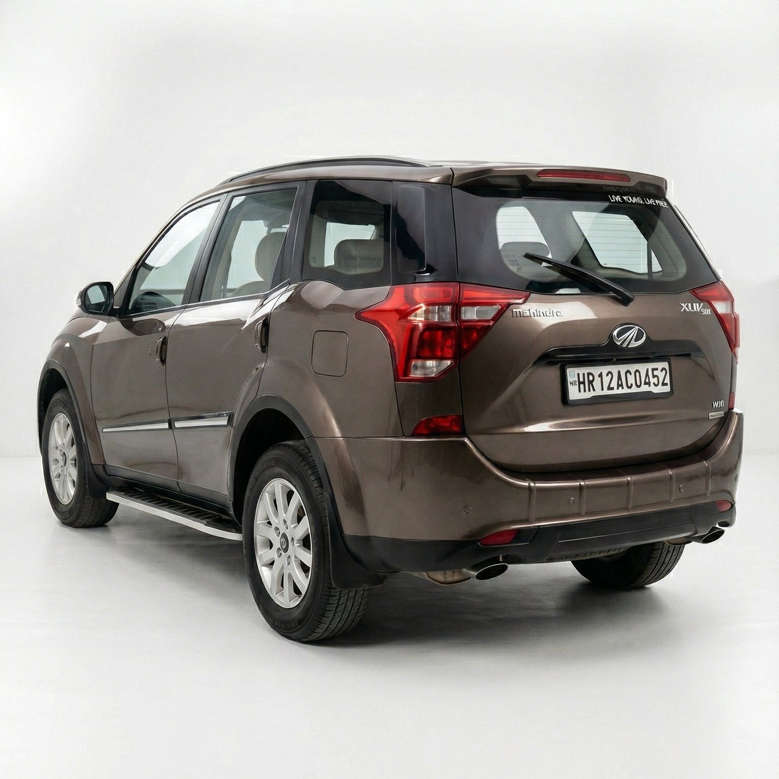Brown SUV with a visible license plate on a white background