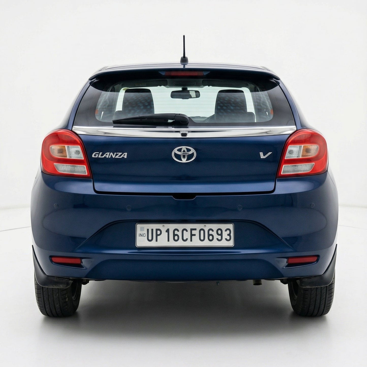 Blue Toyota Glanza car shown from the rear on a white background