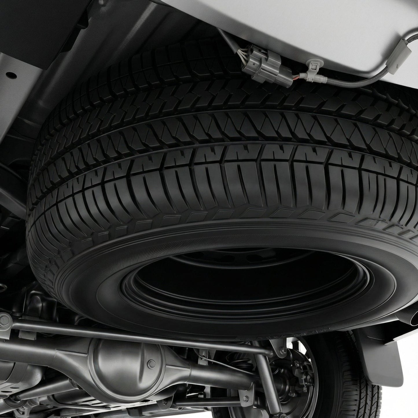 Close-up of a vehicle's undercarriage with a tire on a white background