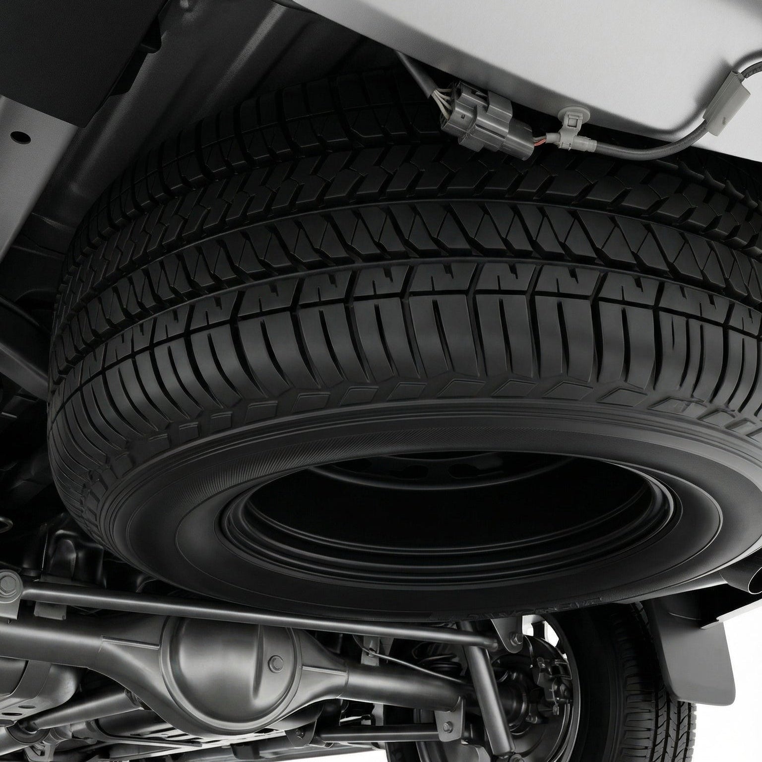 Close-up of a vehicle's undercarriage with a tire on a white background