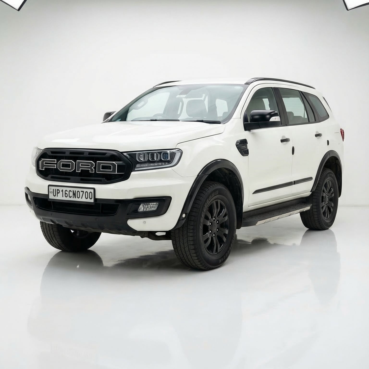 White Ford SUV on a reflective white surface with geometric black patterns in the background