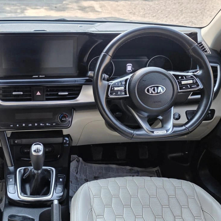 Car interior with dashboard, steering wheel, and gear shift in a Kia vehicle.