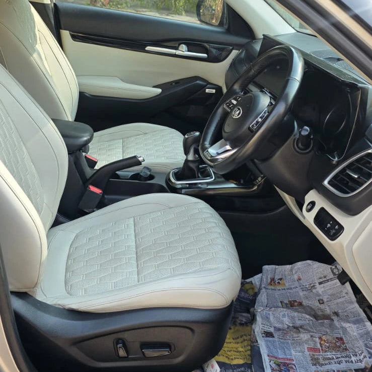 Car interior with beige seats and a newspaper on the dashboard