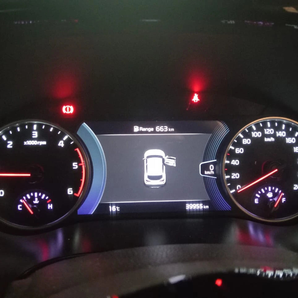 Car dashboard with digital display and gauges at night