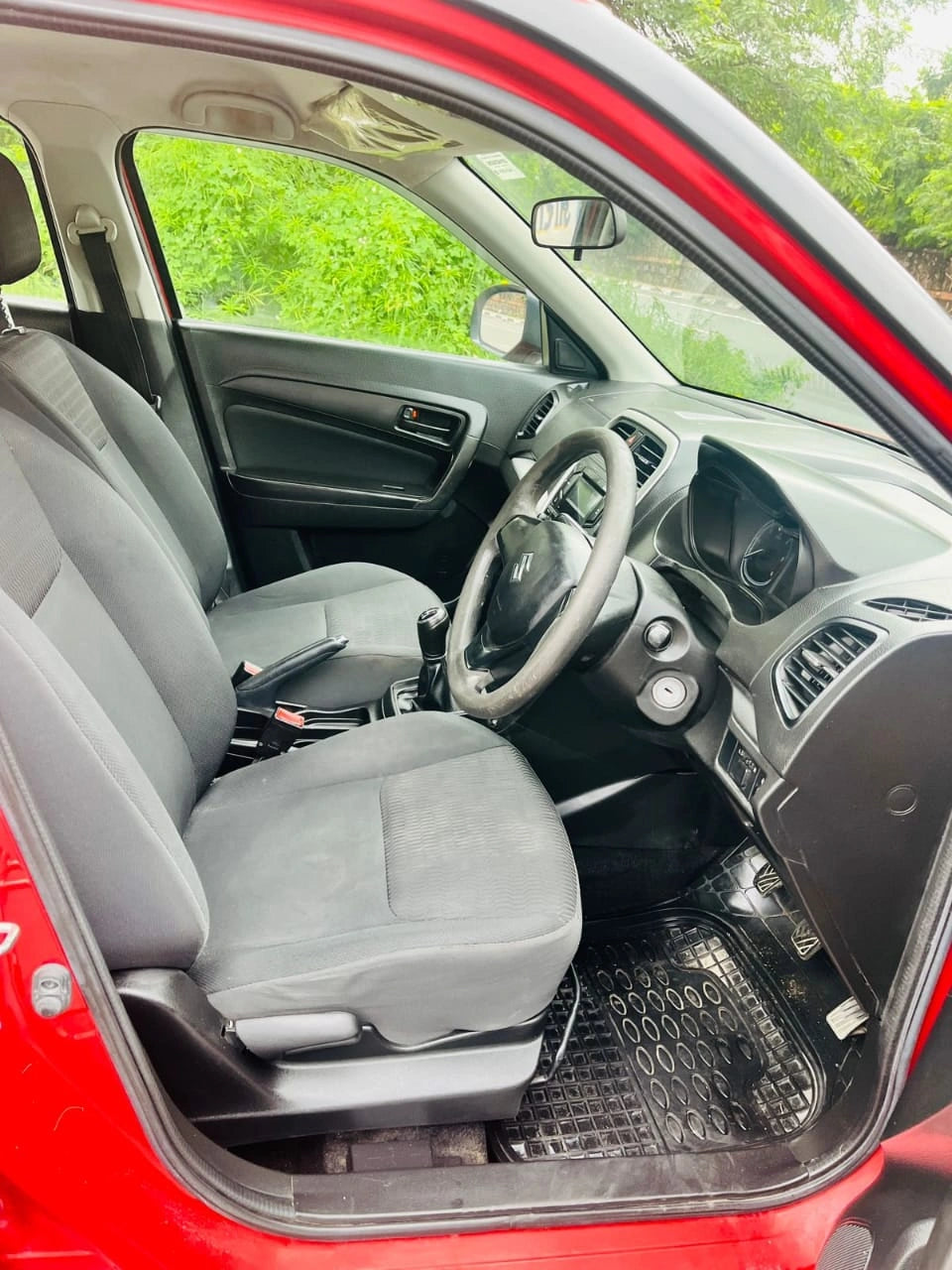 Interior of a red car with gray seats and dashboard.