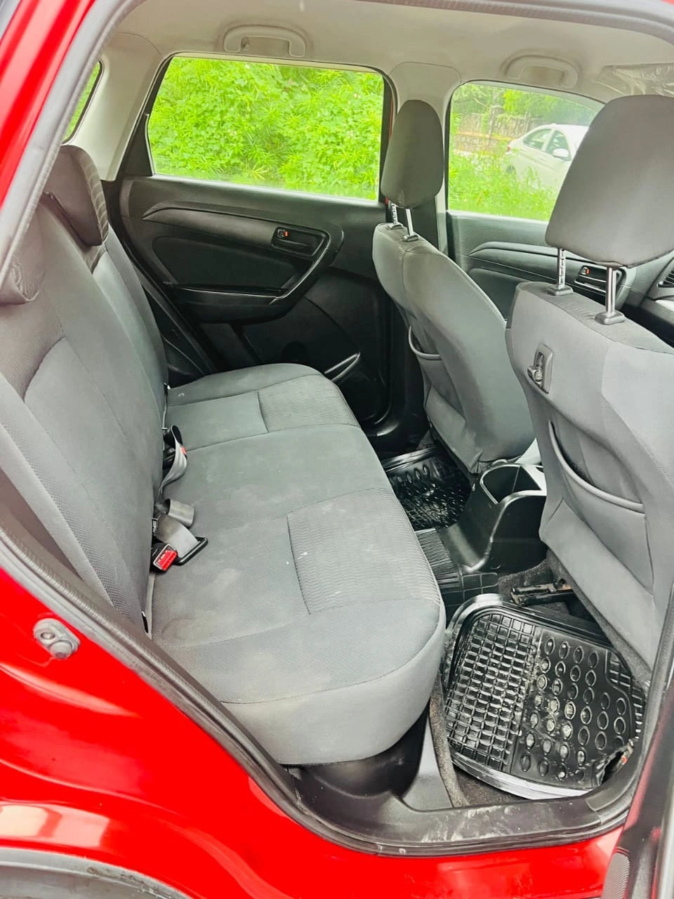 Back seat of a car with gray seats and a red exterior