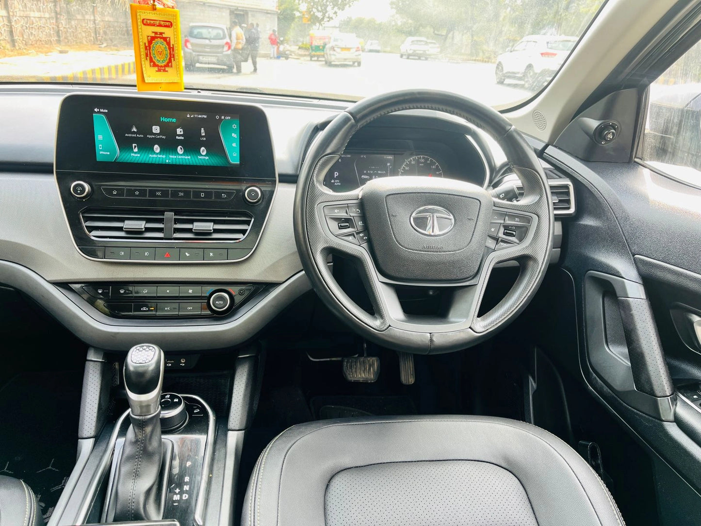 Car interior with dashboard, steering wheel, and gear shift in a vehicle.