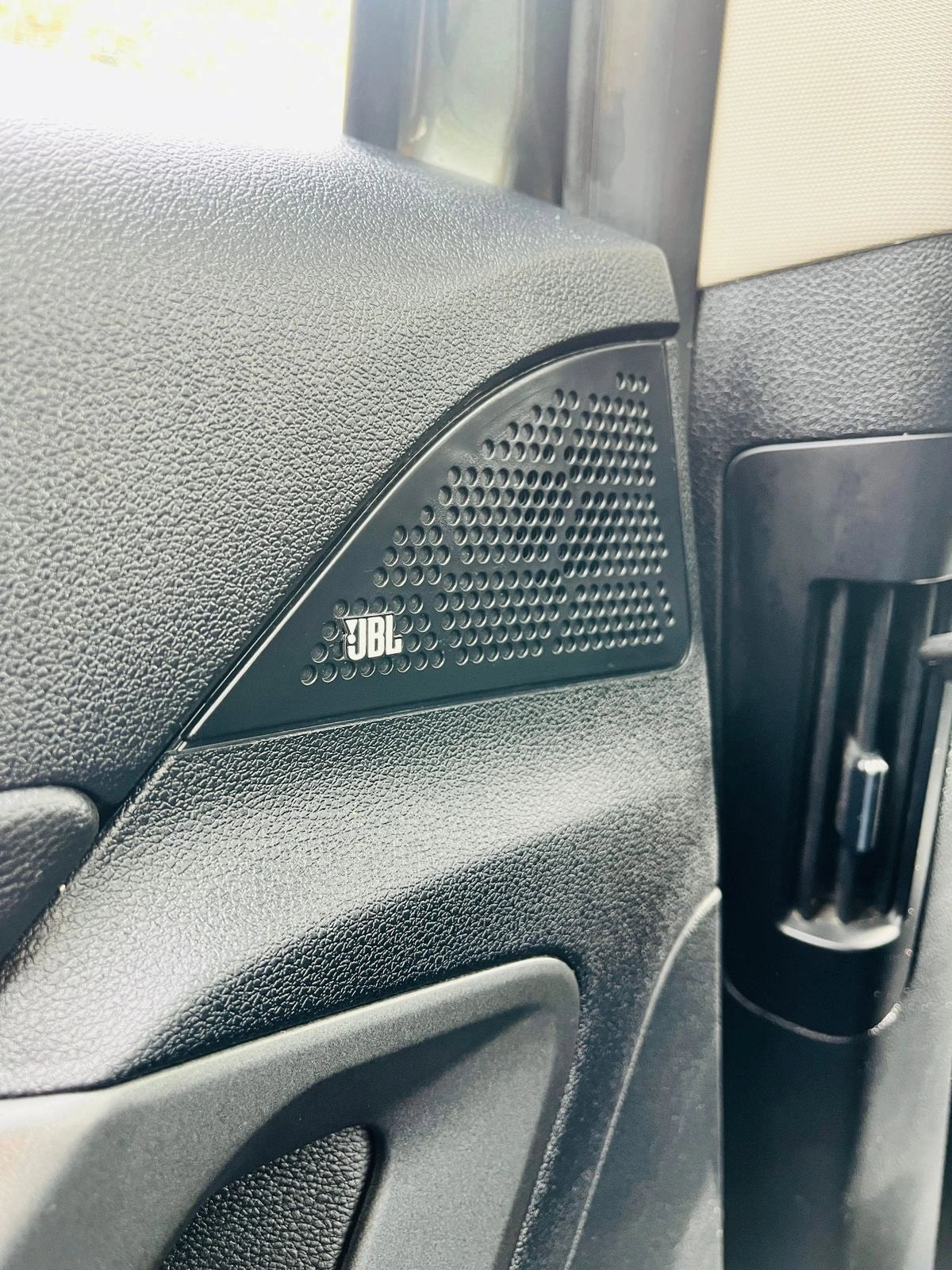Car interior with JBL speaker grille
