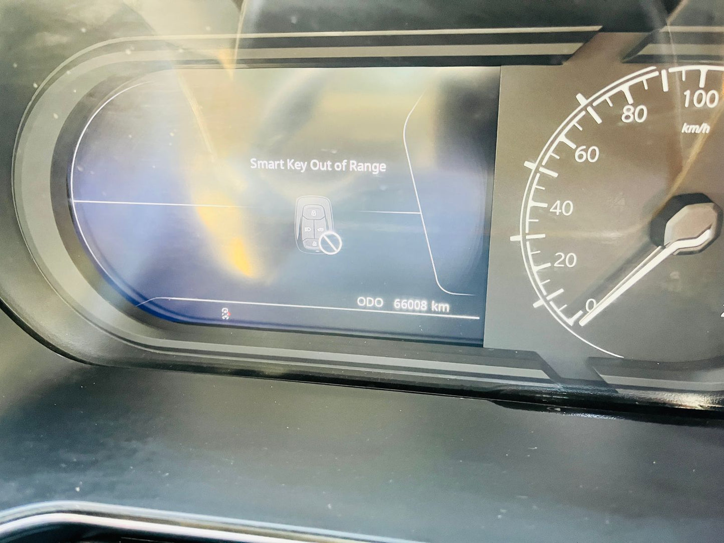 Car dashboard with digital display showing 'Smart Key Out of Range' message.