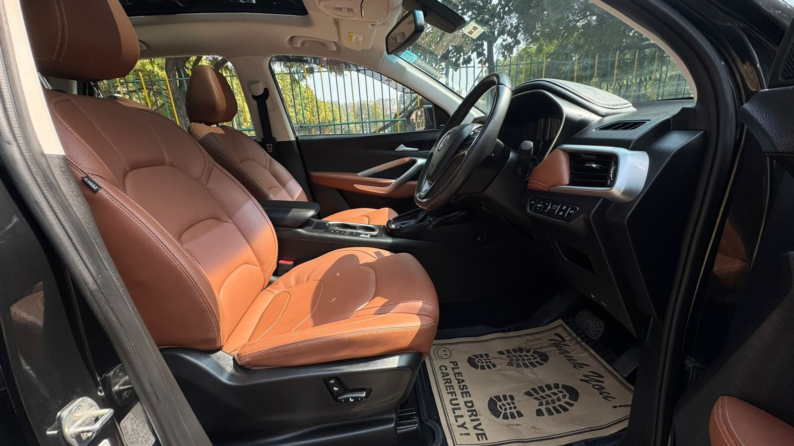 Car interior with orange seats and a black and white mat on the floor.