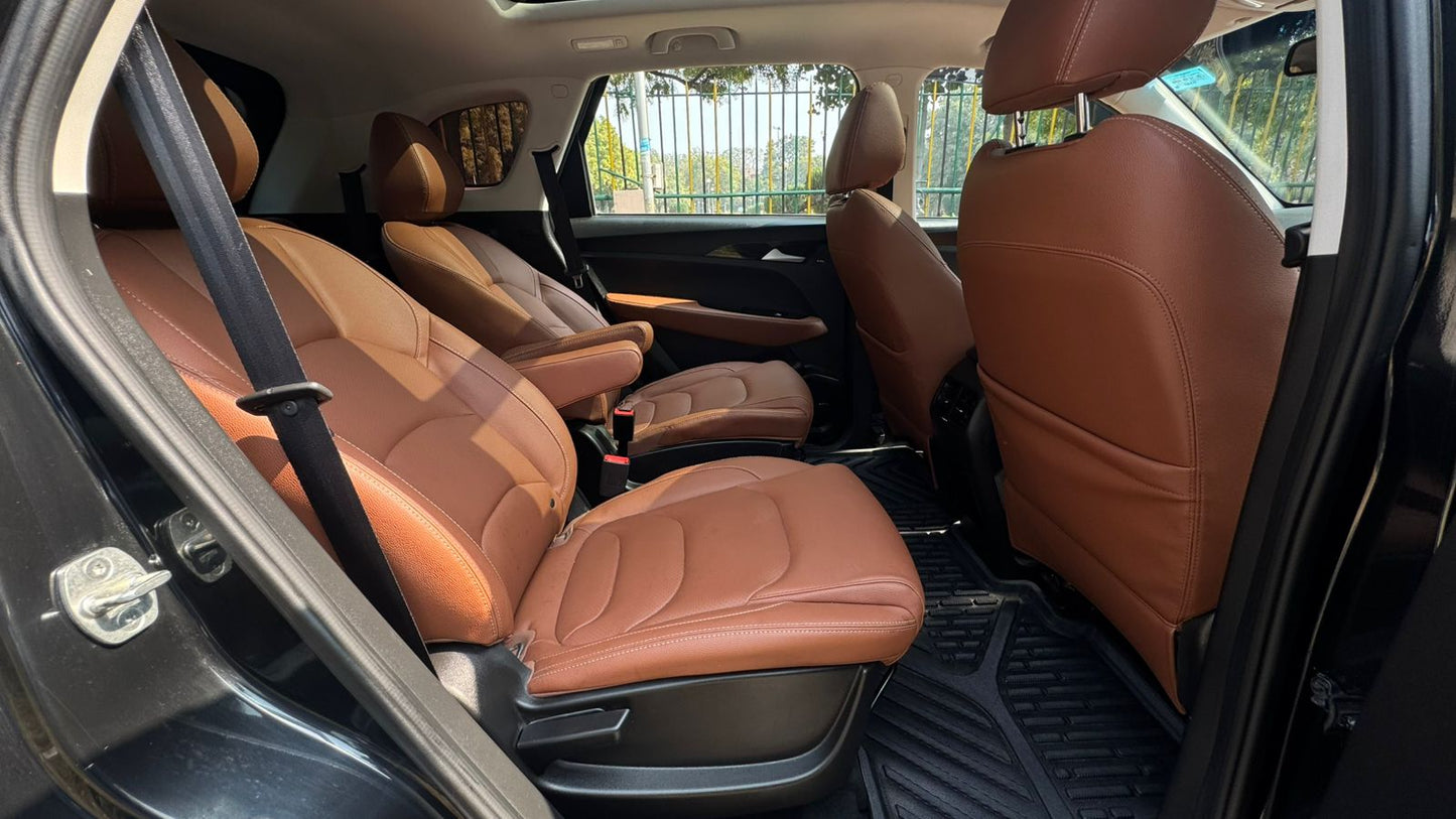 Brown leather interior of a car with open door