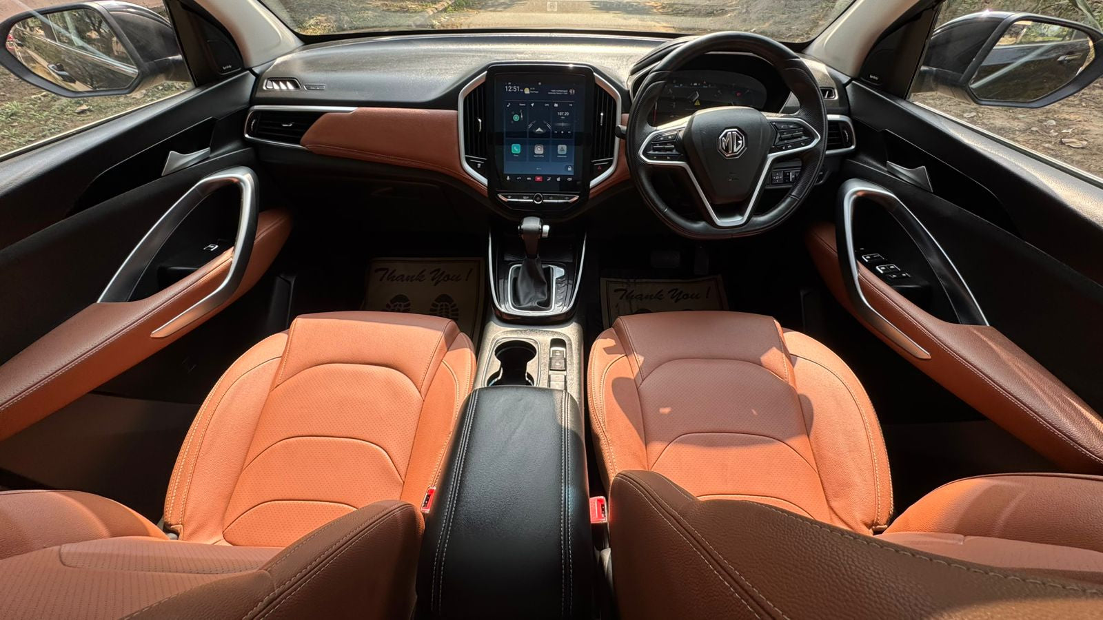Car interior with orange leather seats and a modern dashboard.