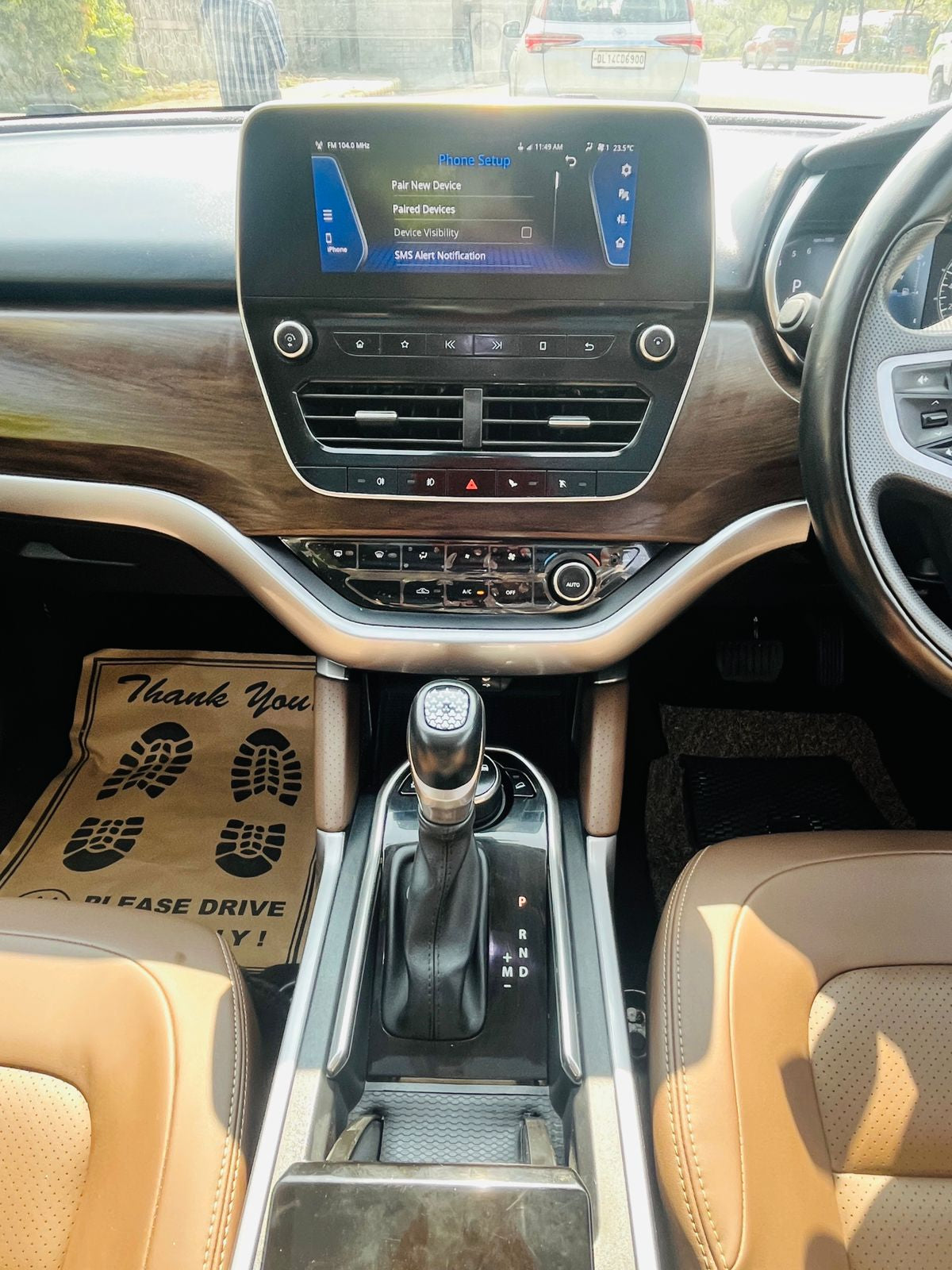 Car interior with dashboard, steering wheel, and gear shift.