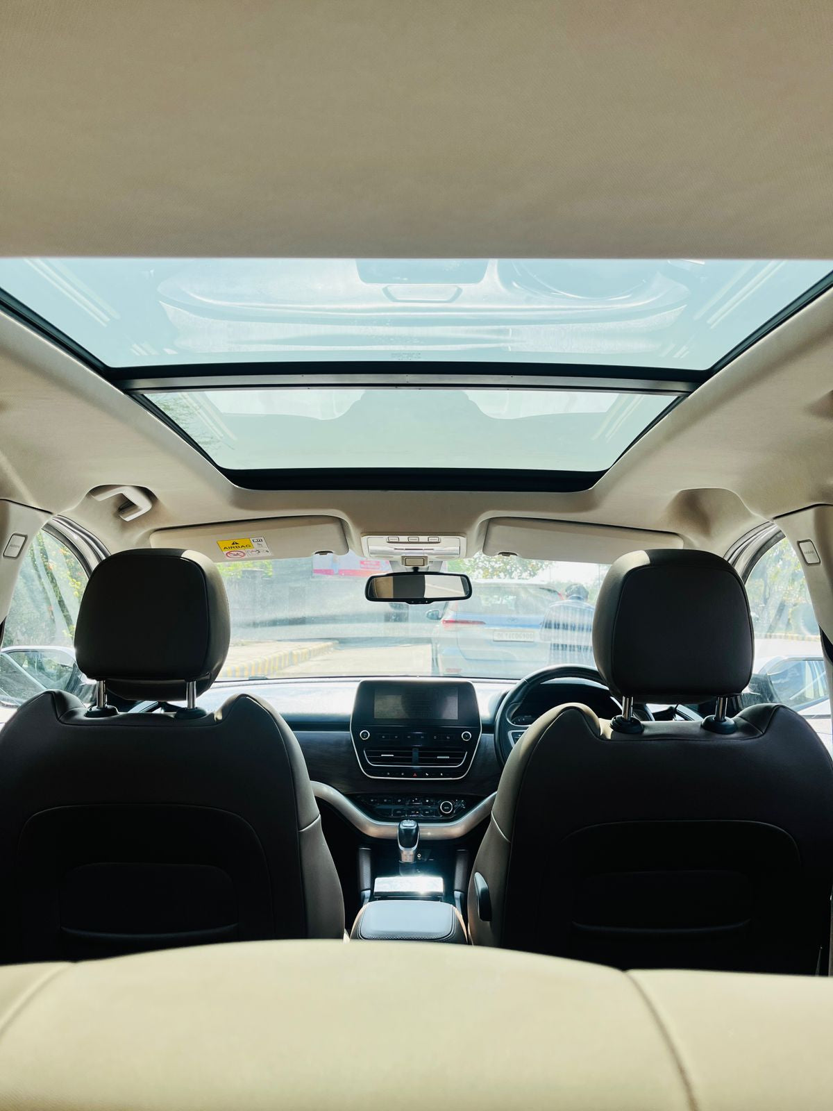 Car interior with a sunroof, showing the dashboard and front seats.