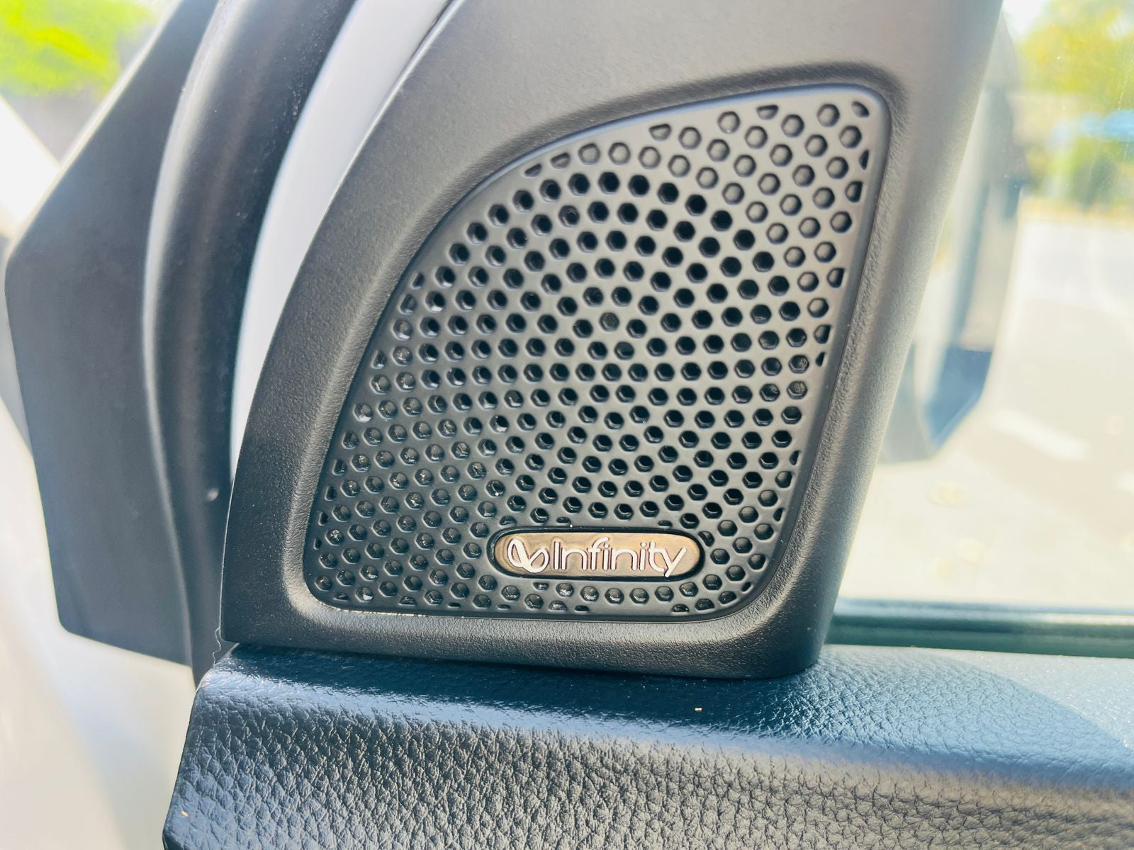 Car speaker with Infinity logo on a car interior