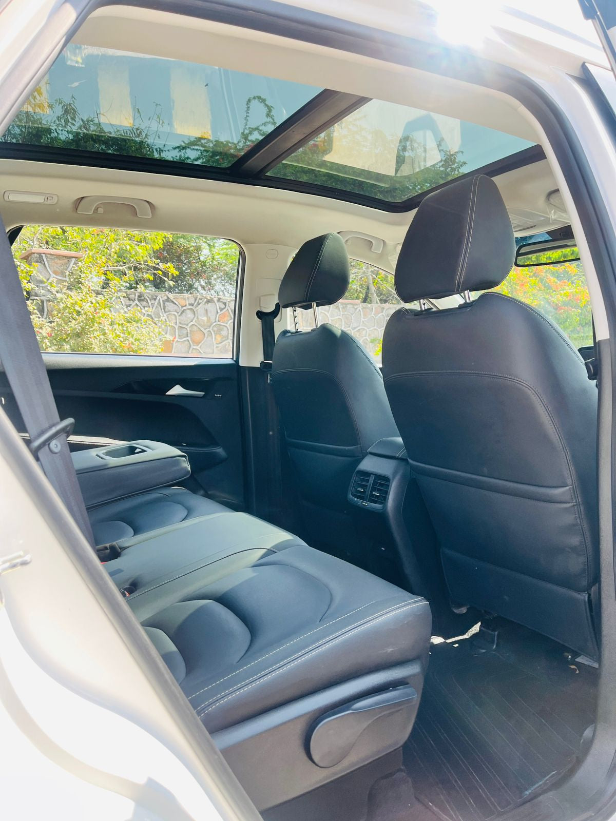 Back seat of a car with a sunroof, showing the interior design and layout.