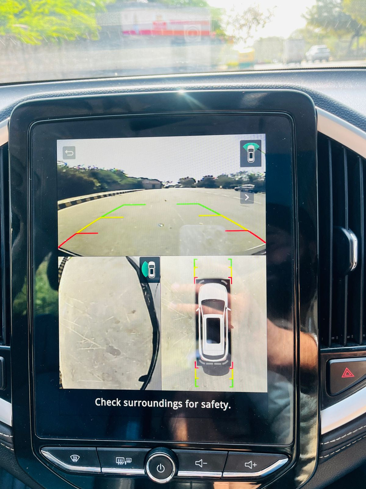 Car dashboard with a navigation screen displaying a 360-degree view of the car's surroundings.