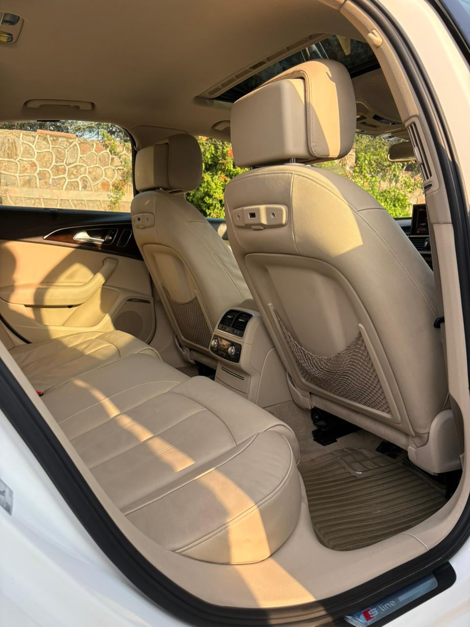Beige interior of a car with visible sun shining on the seats