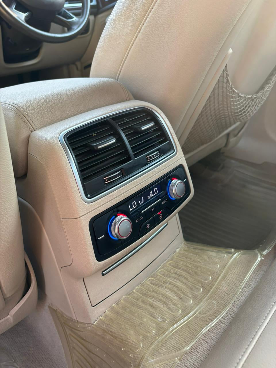 Car interior with air vent and audio controls on a beige dashboard.