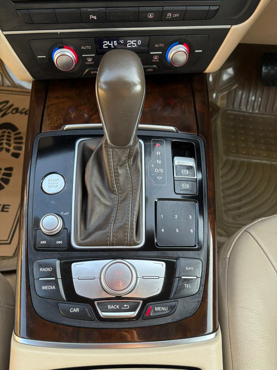 Car gear shift lever with control buttons in a vehicle interior.