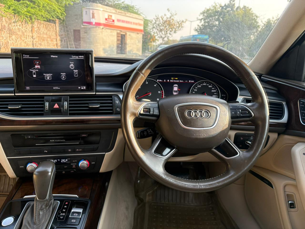 Car interior with steering wheel and dashboard, showing Audi logo.