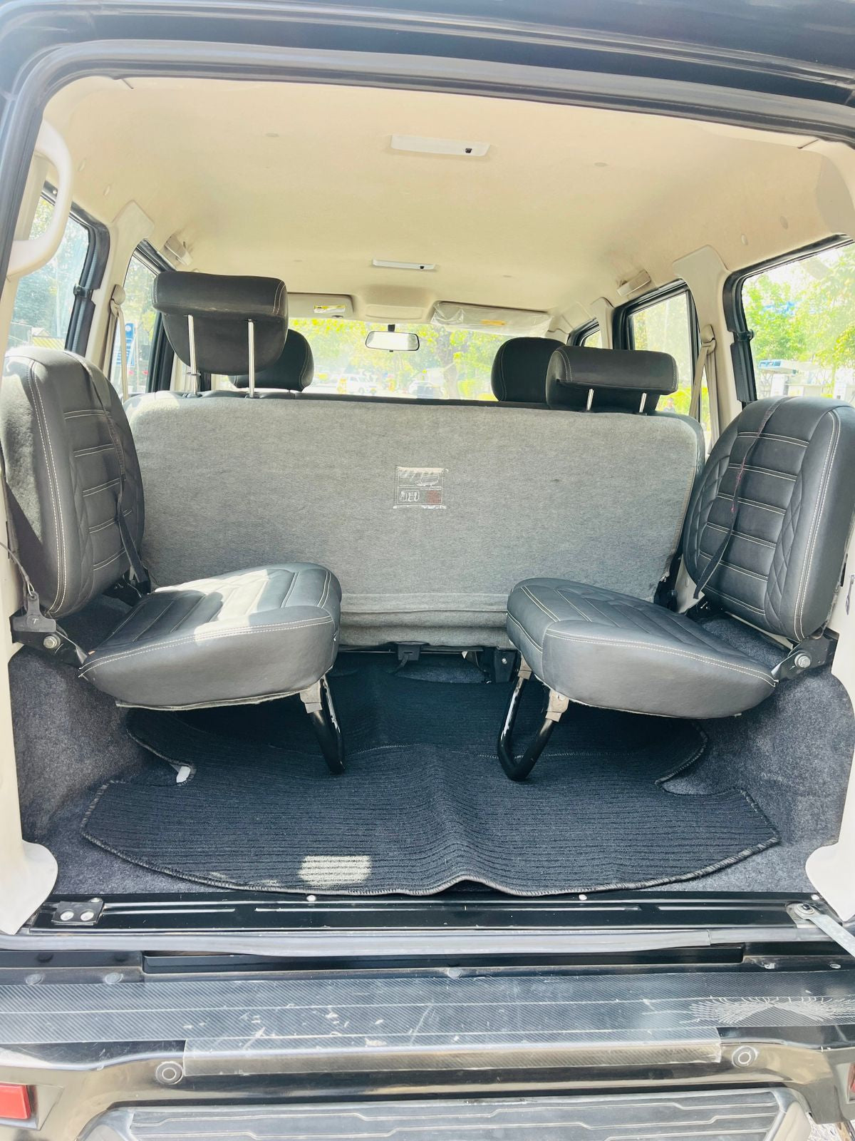 Van interior with gray seats and a black floor mat.
