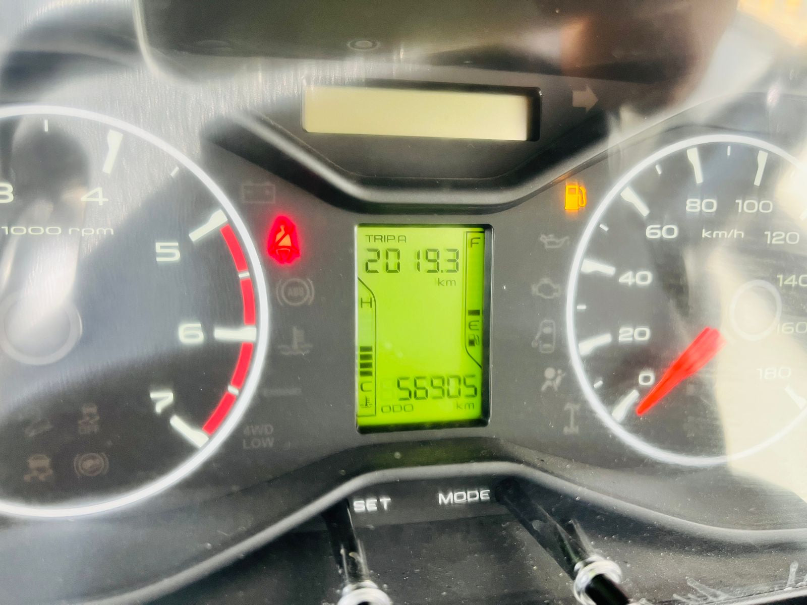 Car dashboard with digital speedometer and various gauges.