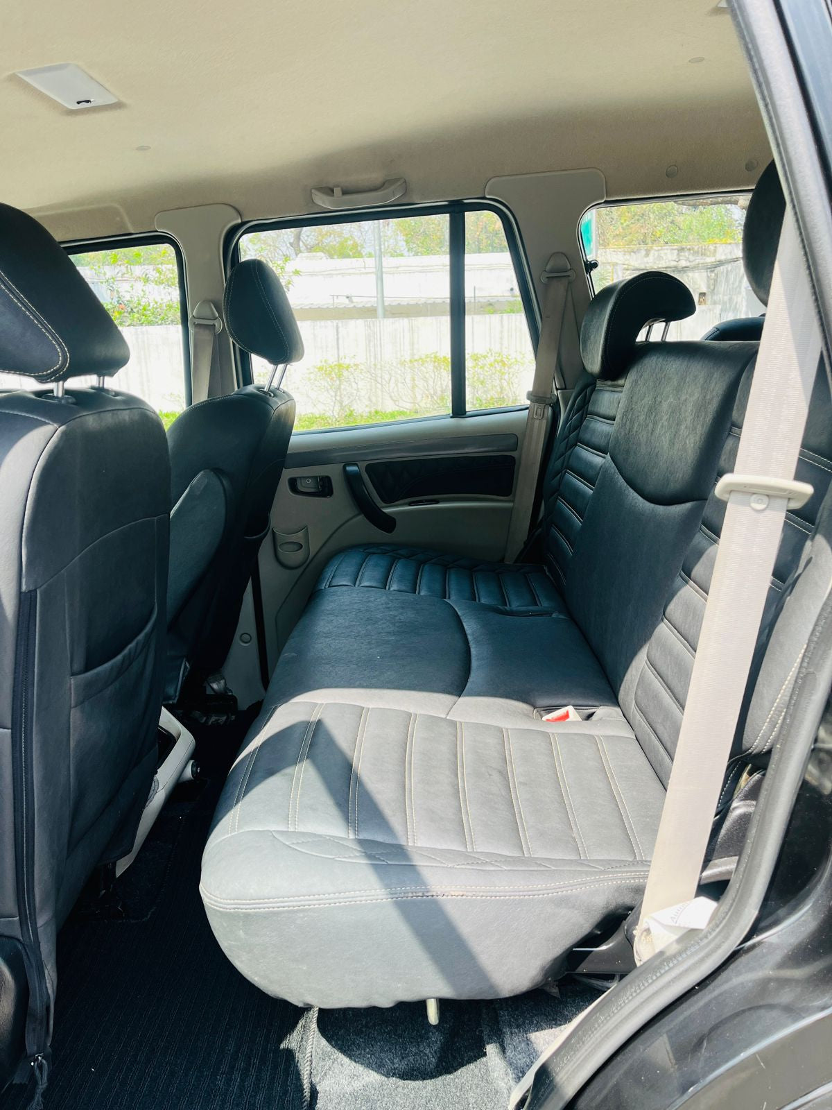 Backseat of a vehicle with gray and blue seats, showing the interior design.