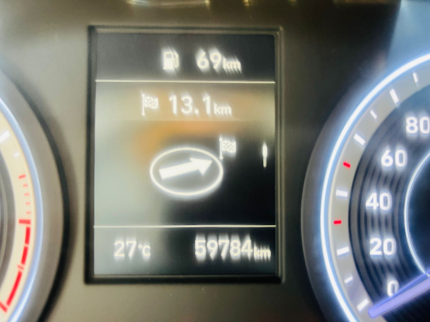 Car dashboard display showing distance, temperature, and mileage.