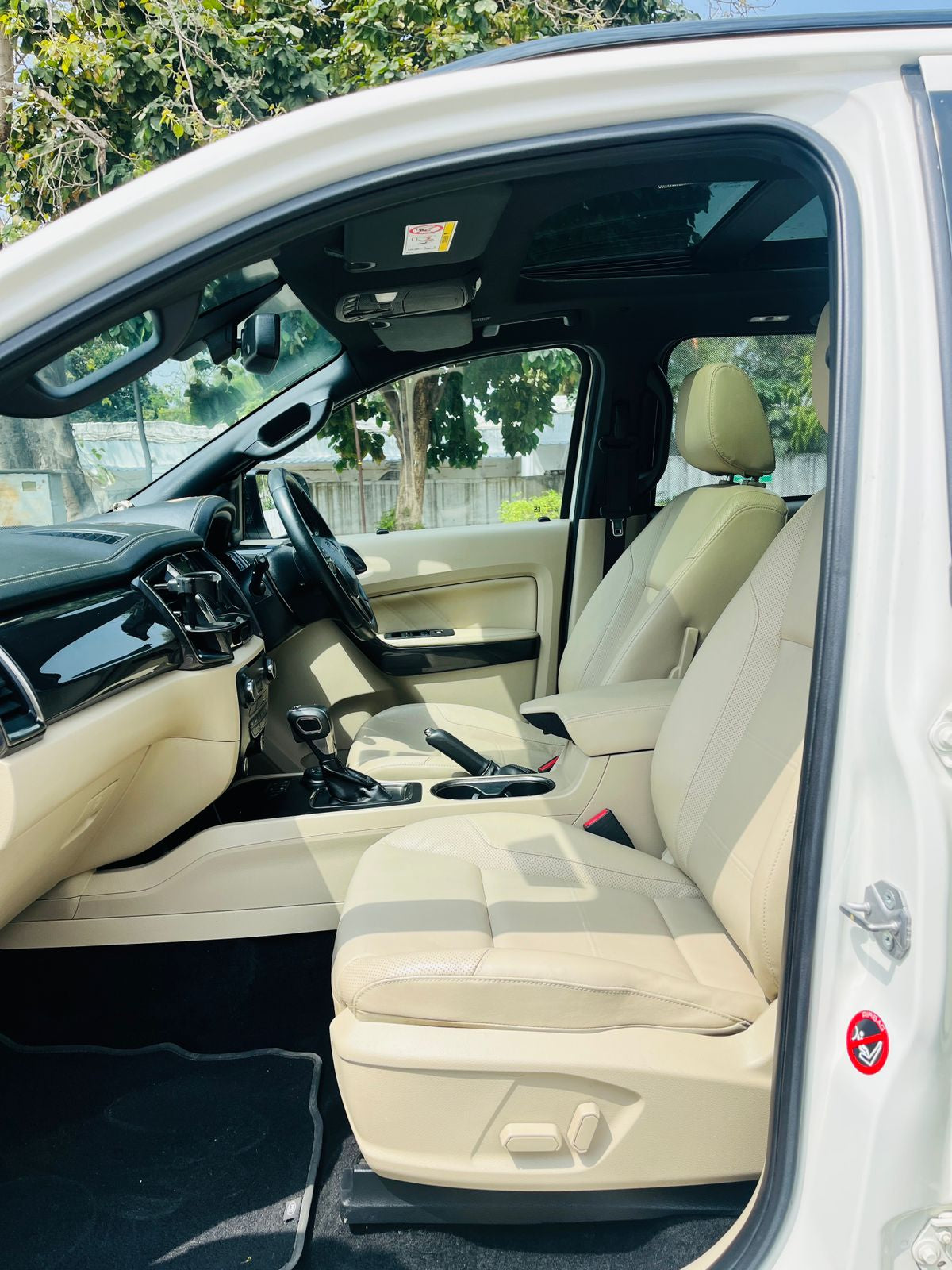 Beige interior of a vehicle with steering wheel and dashboard.