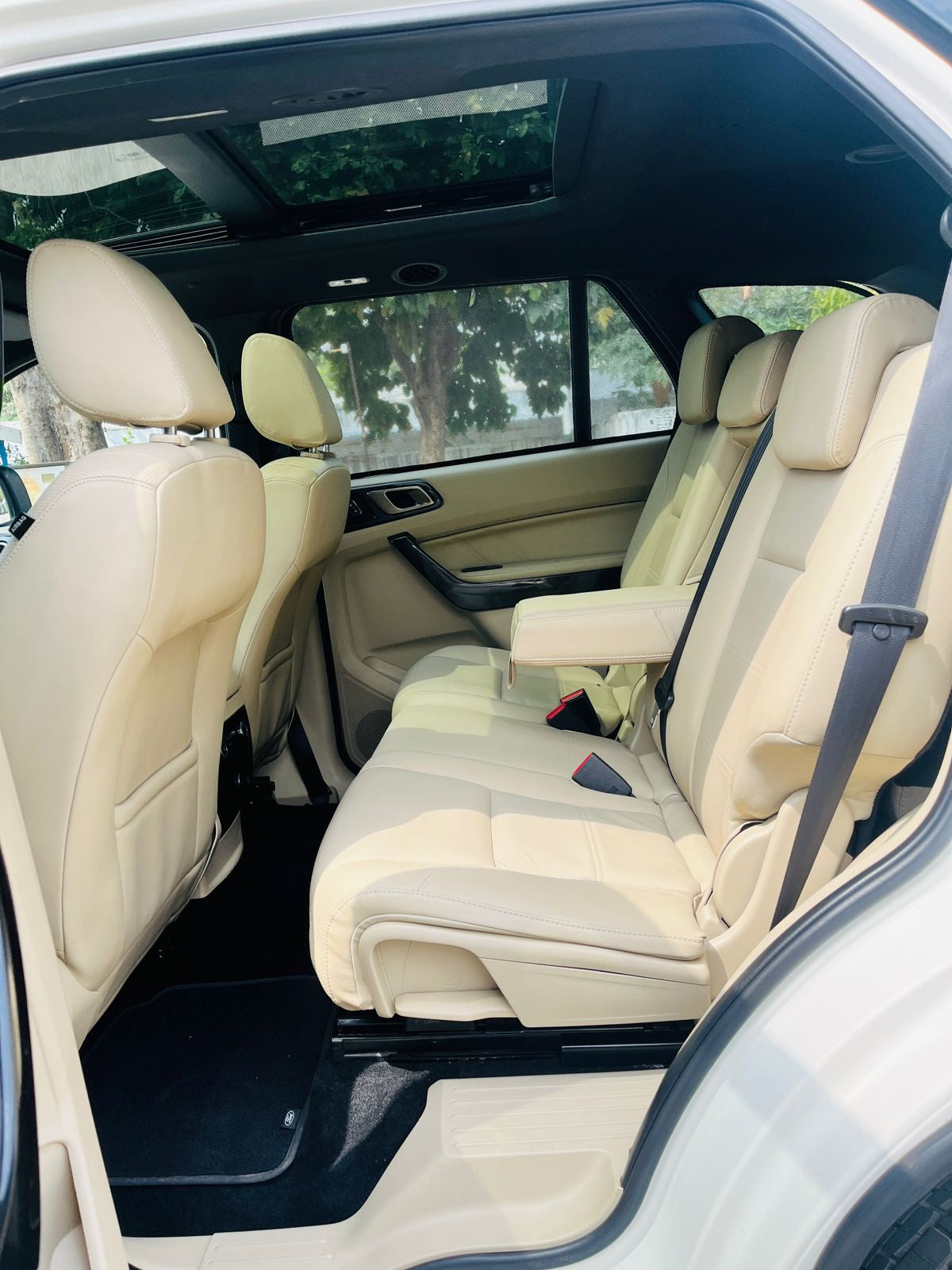 Beige interior of a car with visible seats and dashboard.