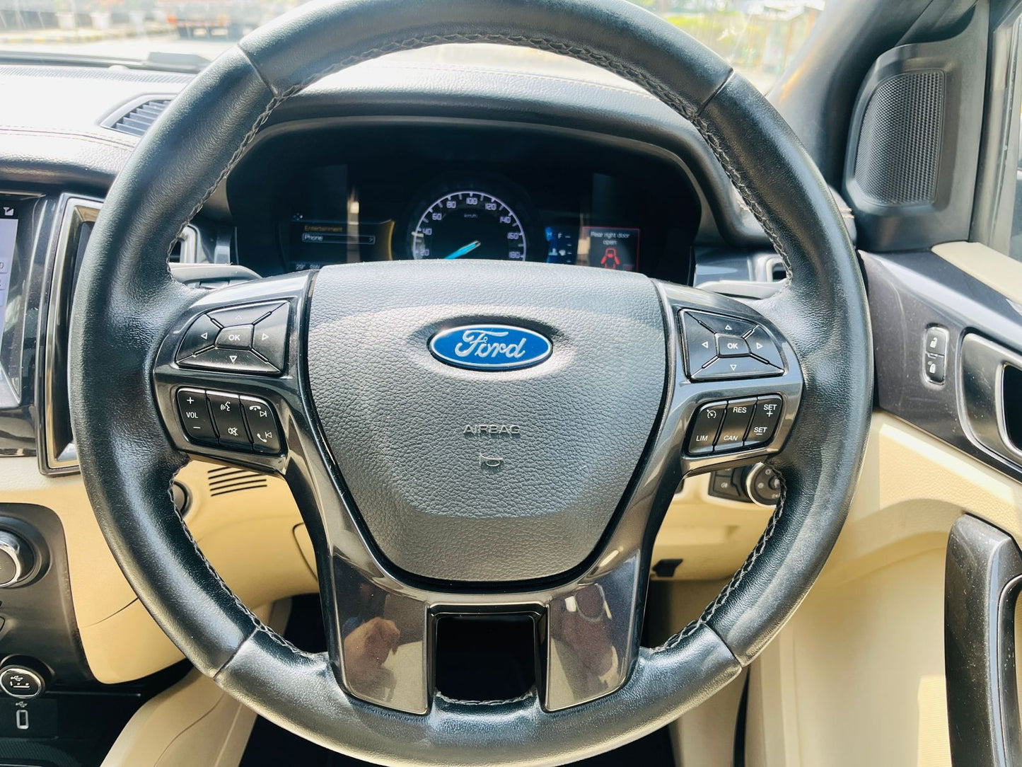 Steering wheel of a Ford vehicle with dashboard in the background
