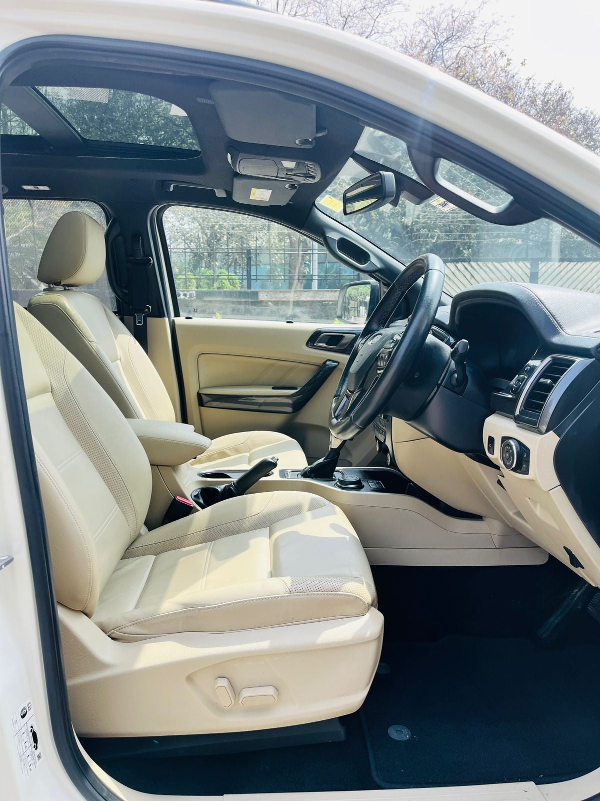 Beige interior of a car with steering wheel and dashboard visible