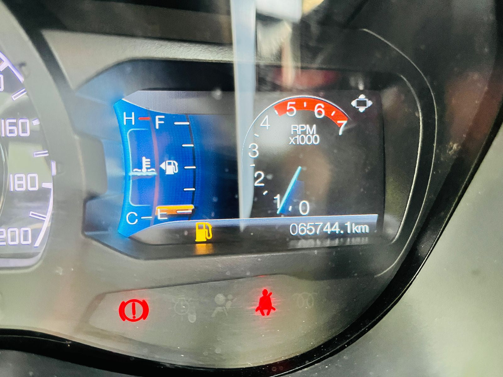 Car dashboard with digital display showing various metrics.
