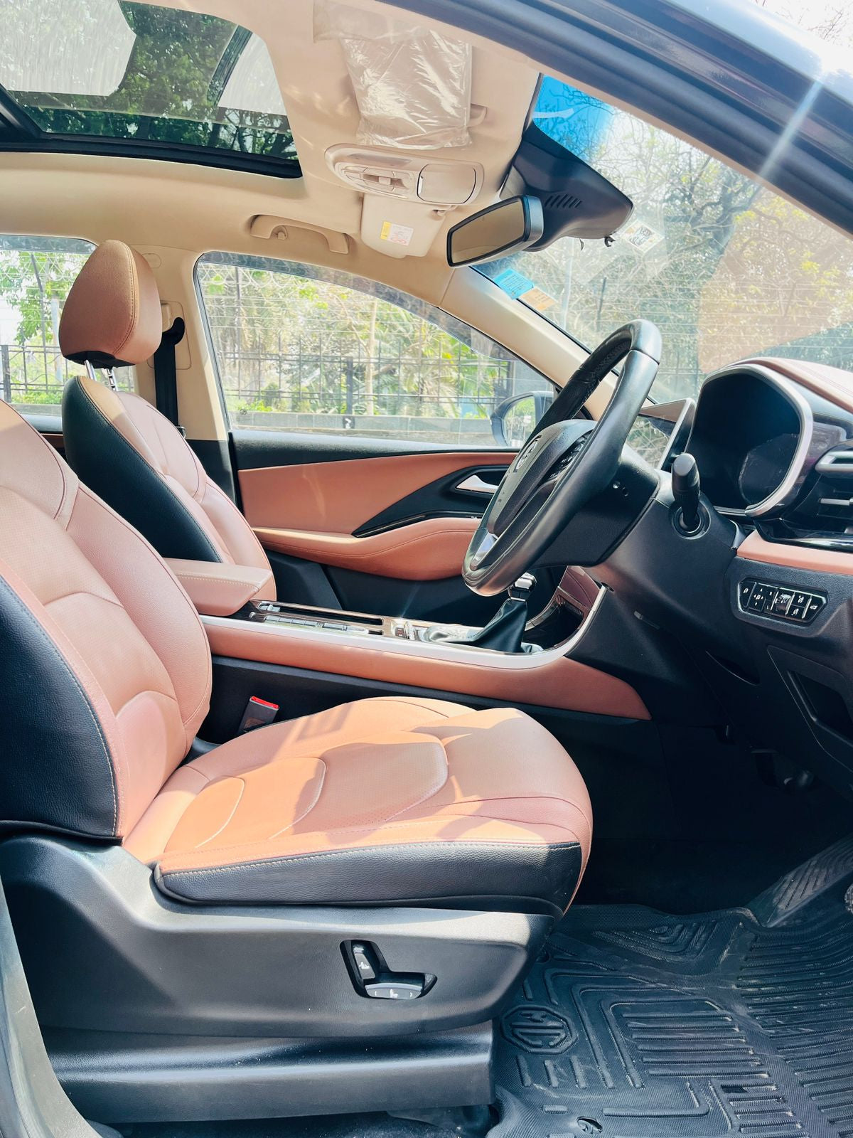 Car interior with beige and black seats and dashboard.