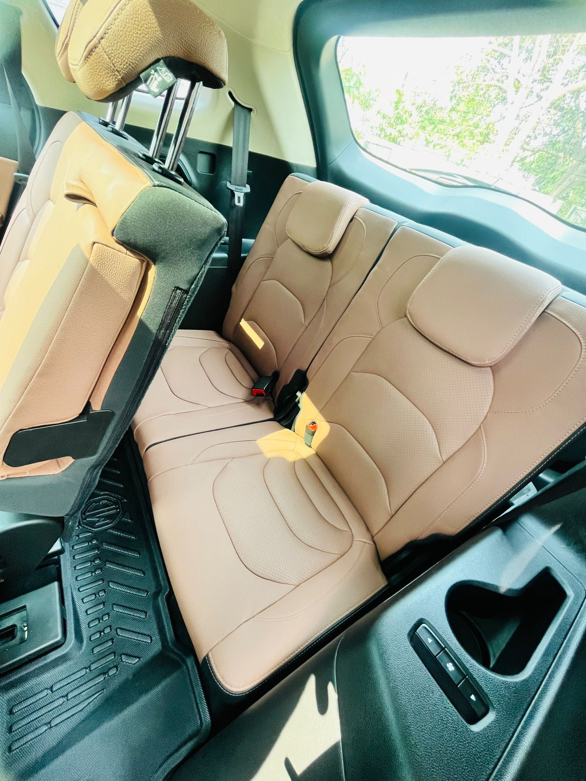 Beige car interior with folded seat and open door