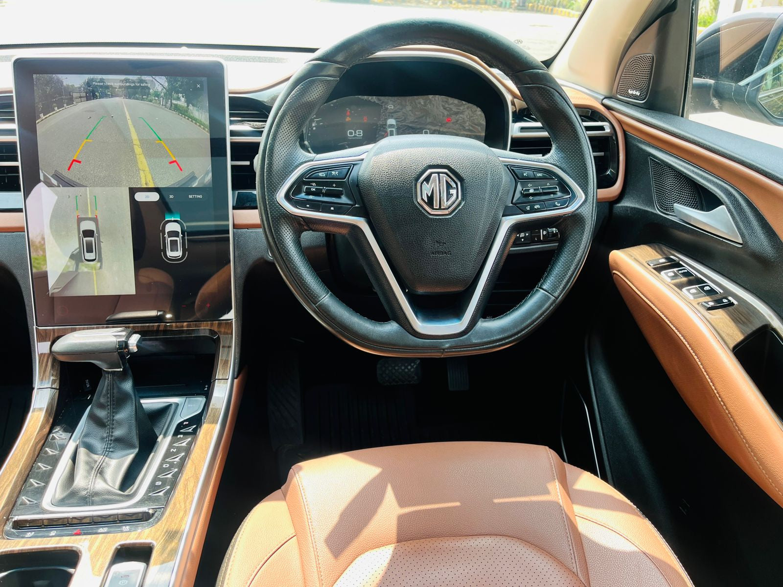 Car interior with steering wheel and dashboard displaying MG logo