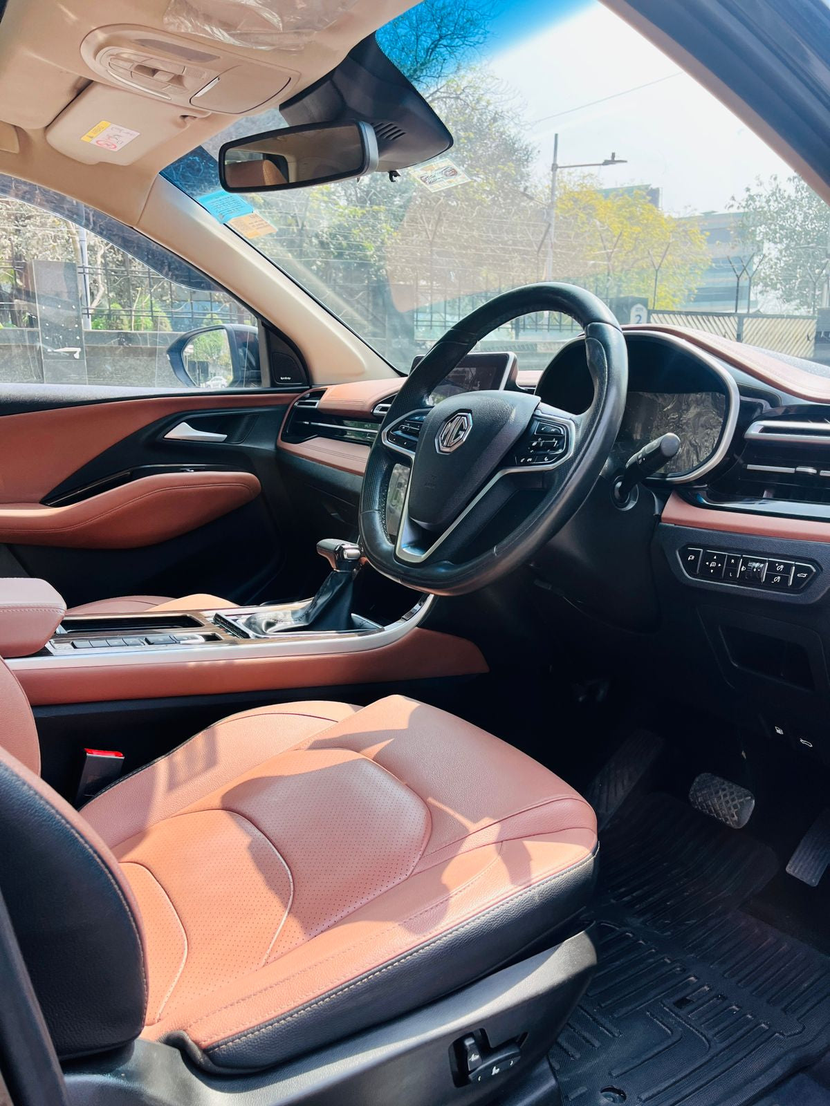Car interior with brown leather seats and steering wheel.