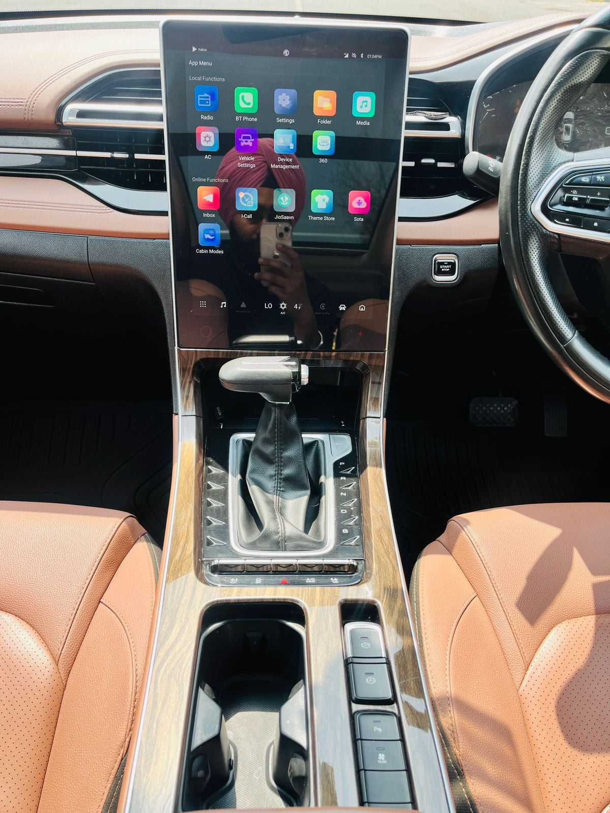 Car interior with a large touchscreen display and gear shift.